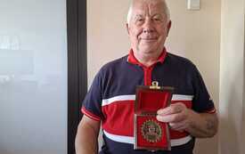 Zeno Perkowski trzyma pamiątkowy medal