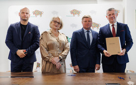 Wicemraszałek wiesława Burnos Wicemarszałek Marek Malinowski i Burmistrza Łap Krzystzof Gołaszewski stoja uśmiechnięci z podpisana umową