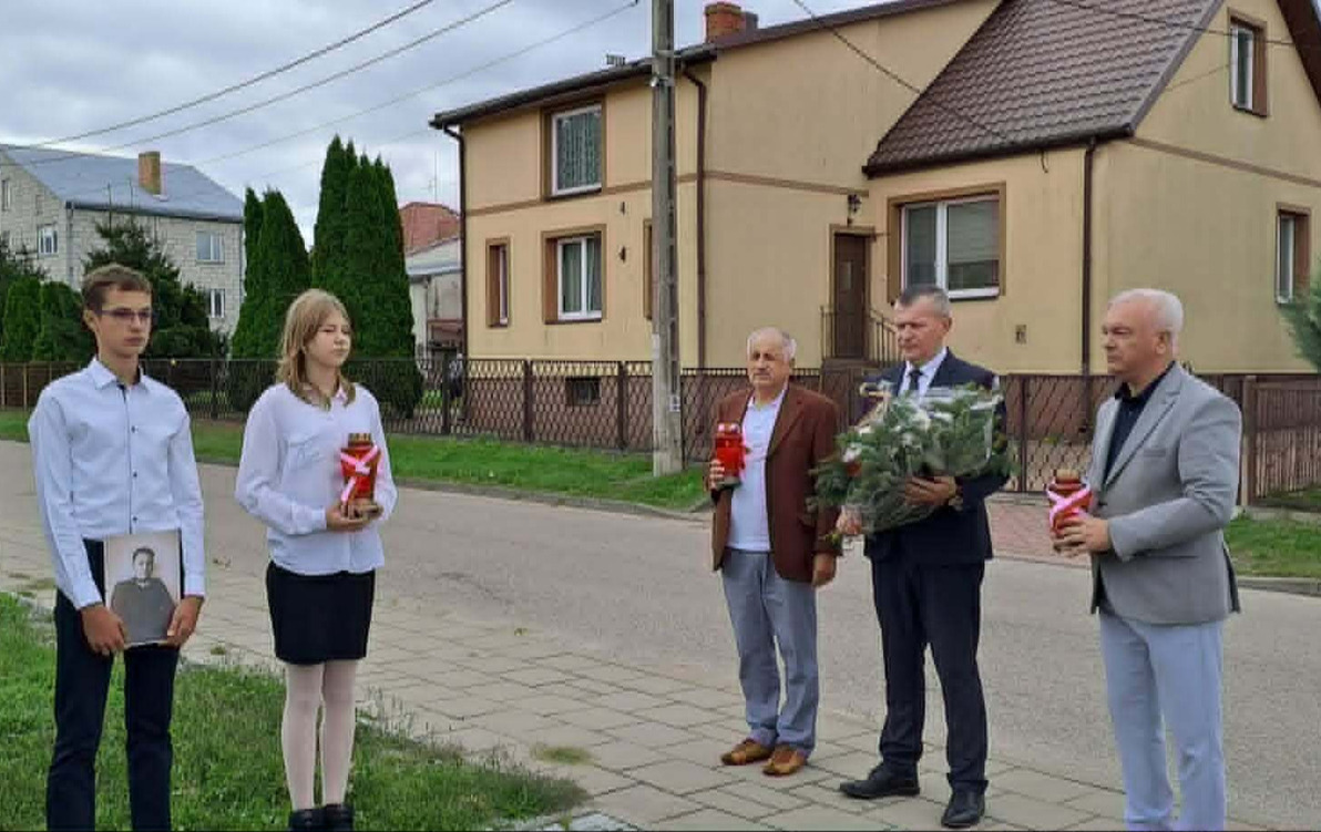burmistrz Łap krzystzof gołaszewski i dyrektor szkoły Krzystzof Łapiński składaja kwiaty przy obelisku
