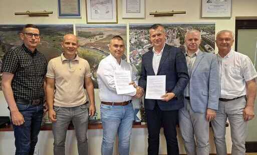Osoby zaangażowane w projekt z burmistrzem Krzysztofem Gołaszewskim stoją z podpisana umową
