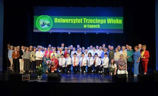 członkowie UTW stoją na zdjęciu grupowym z burmistrzem Łap Krzystzofem Gołaszewskim na zakończenie roku akademickiego
