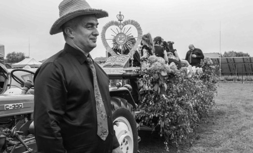 Krzysztof Roszkowski w tle wóz dożynkowy, zdjęcie czarno-białe