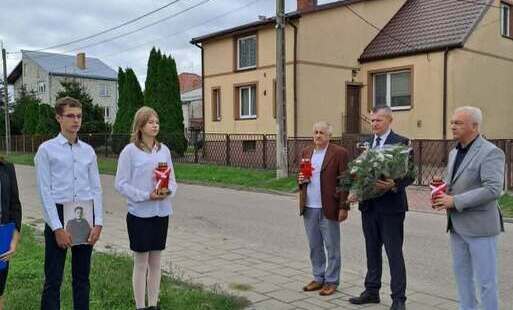 burmistrz Łap krzystzof gołaszewski i dyrektor szkoły Krzystzof Łapiński składaja kwiaty przy obelisku