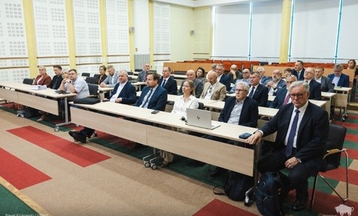 osoby uczestniczące w spotkaniu siedzą na sali w ławkach